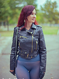 In an autumn park, the redheaded girl named Jeny removes her skirt to pose seductively in her seamless blue pantyhose, wearing only a leather jacket and high boots