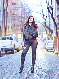 Jeny poses on a city street wearing just a stylish jacket, black seamless pantyhose and tall boots, her feminine curves and private areas fully on display