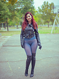 In an autumn park, the redheaded girl named Jeny removes her skirt to pose seductively in her seamless blue pantyhose, wearing only a leather jacket and high boots