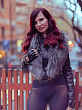 Jeny poses on a city street wearing just a stylish jacket, black seamless pantyhose and tall boots, her feminine curves and private areas fully on display