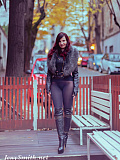 Jeny poses on a city street wearing just a stylish jacket, black seamless pantyhose and tall boots, her feminine curves and private areas fully on display